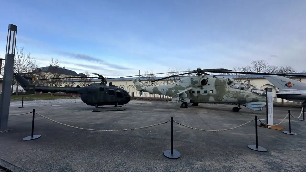 Zwei Hubschrauber der Bundeswehr, ein kleinerer in Tarnfarbe und ein größerer, stehen nebeneinander.